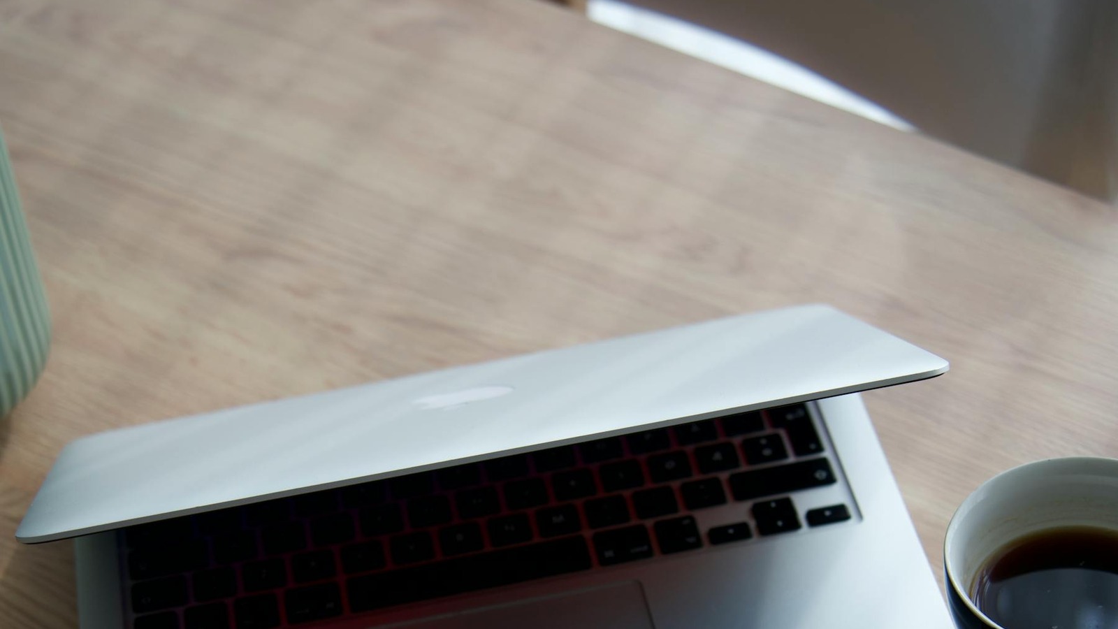 ノートパソコンとコーヒーが置かれた落ち着いたワークスペース
